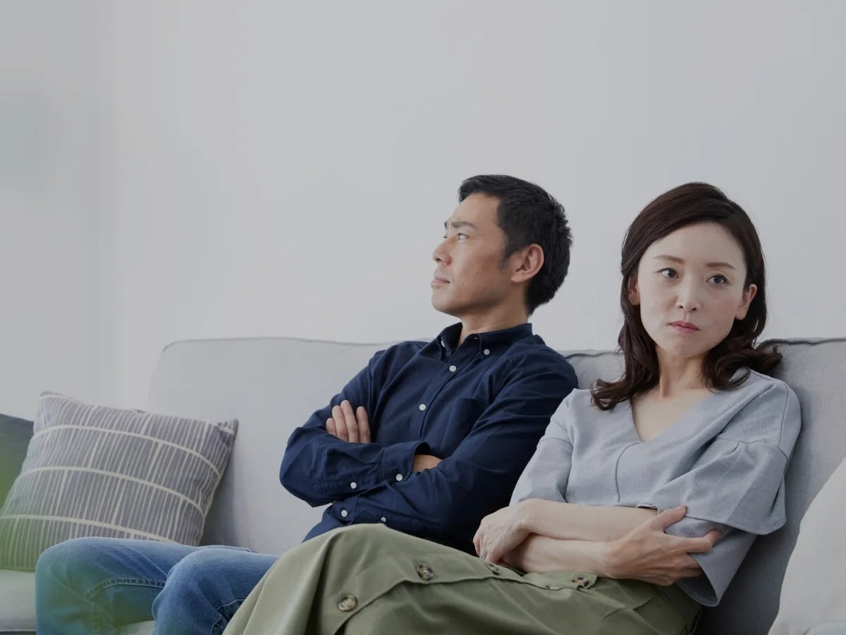 How-to-Make-a-Relationship-Work-With-an-Avoidant-Partner-1 A couple sitting besides each other but their body language reflects distance.