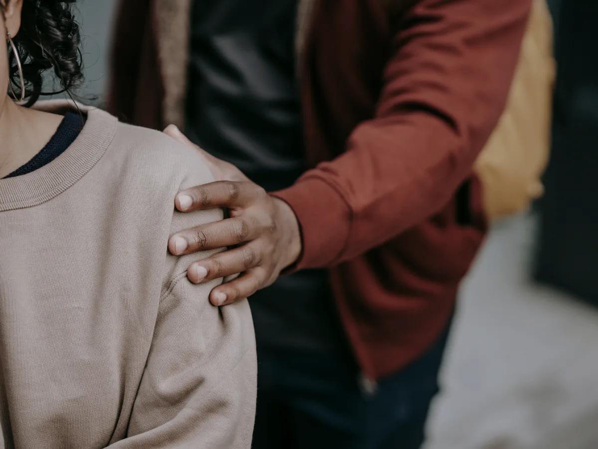How-to-Make-a-Relationship-Work-With-an-Avoidant-Partner-2 A hand reaching out to someone's shoulder. I appears that the other person is being avoidant of person reaching out.